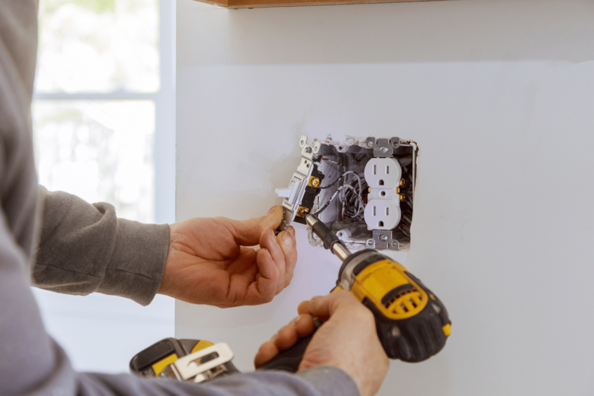 Image of electrician working on apartment outlet